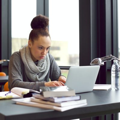 Woman using laptop for taking notes to study